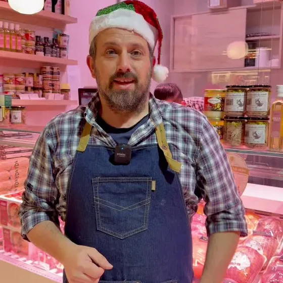 Juan Antonio en el puesto en Navidad, con las aves de fiesta en la vitrina.