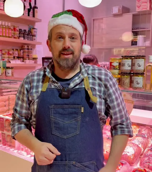 Juan Antonio en el puesto en Navidad, con las aves de fiesta en la vitrina.