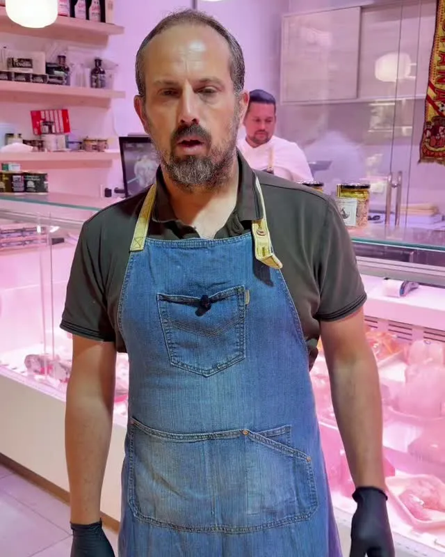 Juan Antonio Fernández en el puesto, con el mostrador de aves al fondo